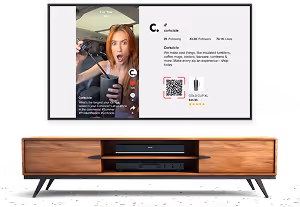 Modern TV on wooden stand showing TikTok video with a surprised woman and product info.