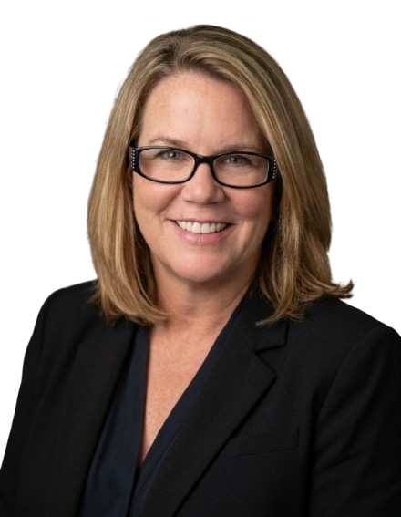 Smiling woman with shoulder-length blonde hair wearing glasses, black blazer, and dark blouse.