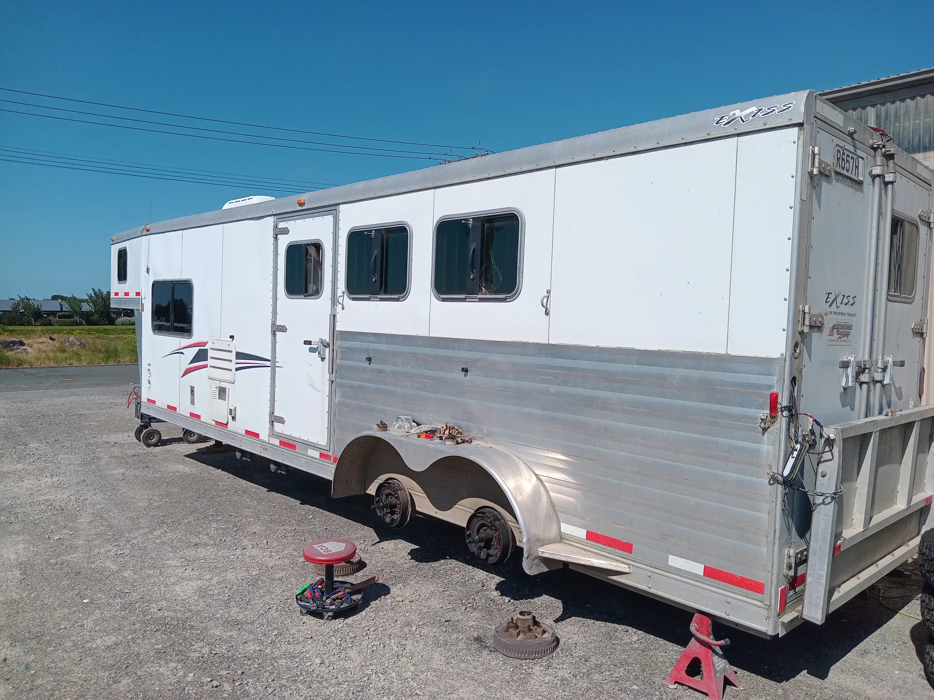A trailer hoisted on a jack with no tyres on outside.