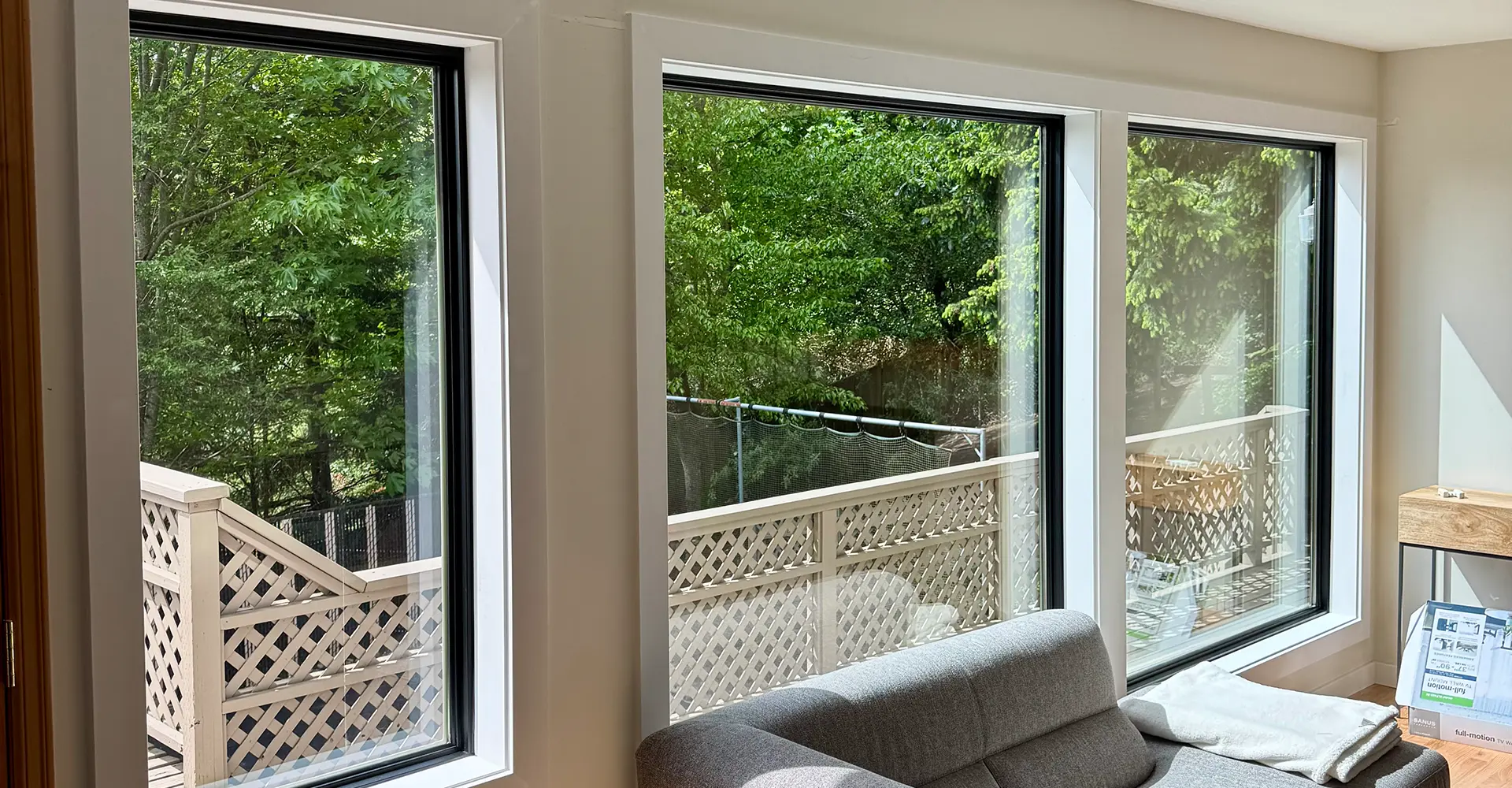 New black-framed replacement windows installed in a Seattle-area living room