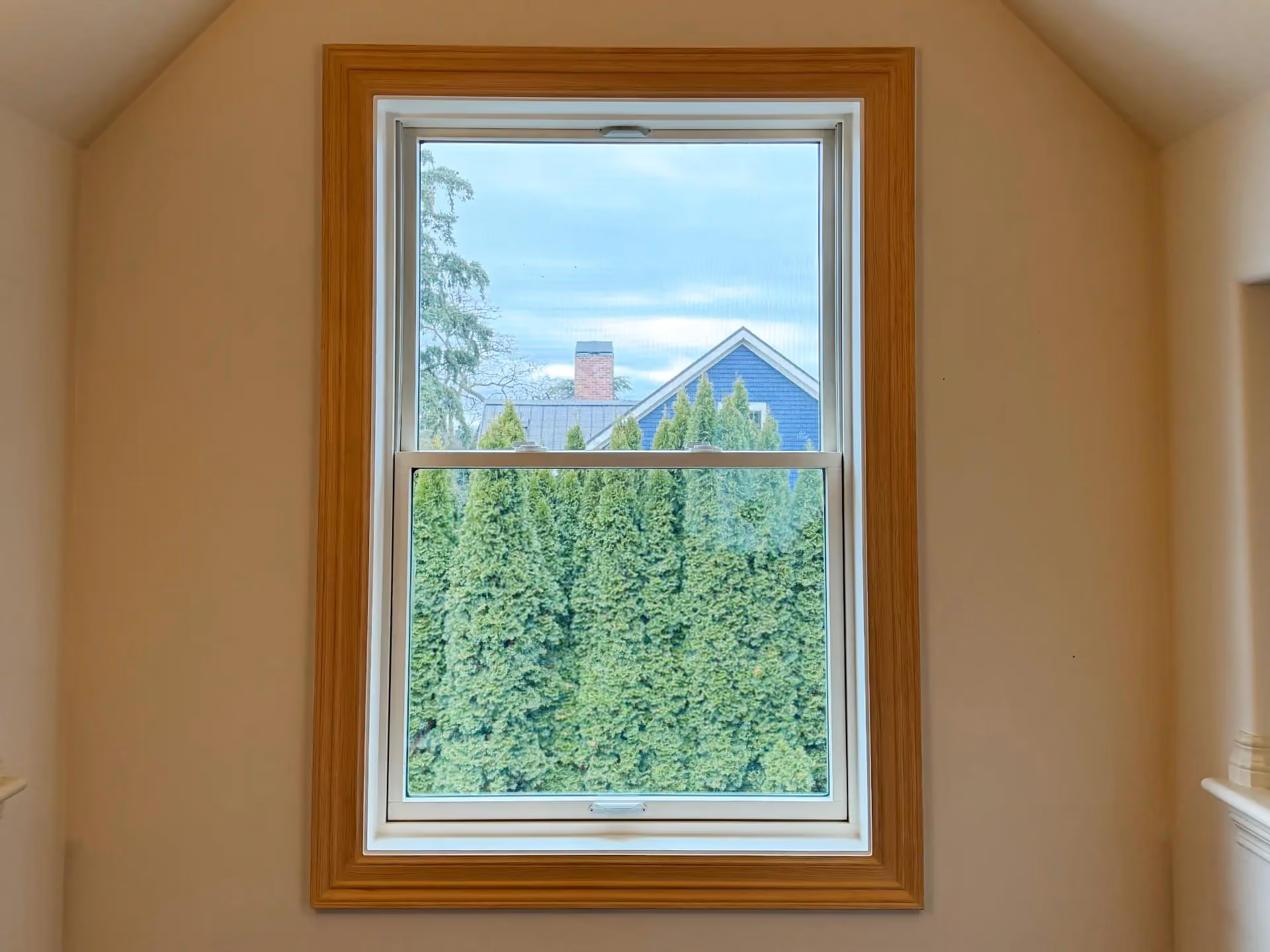 White vinyl replacement window with natural wood interior trim in a Seattle-area home