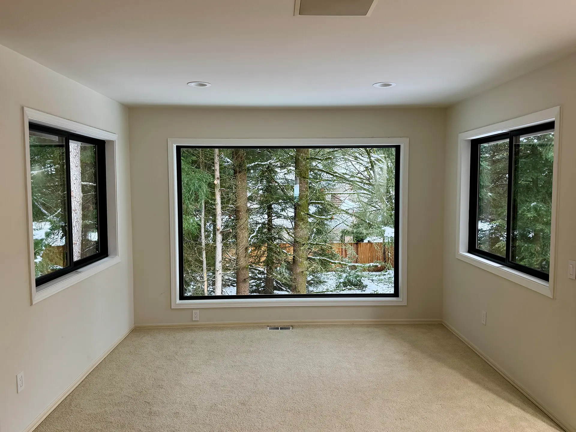 Black-framed replacement windows installed in a bright Seattle-area room