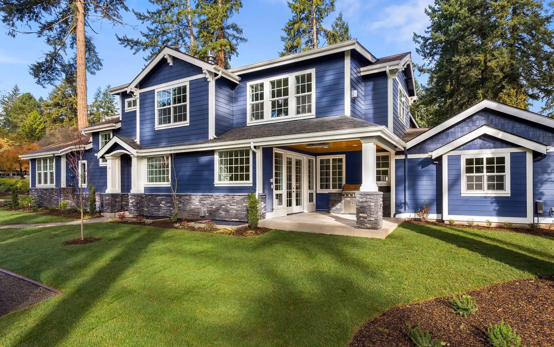 Blue two-story home with a glass-paneled front entry door