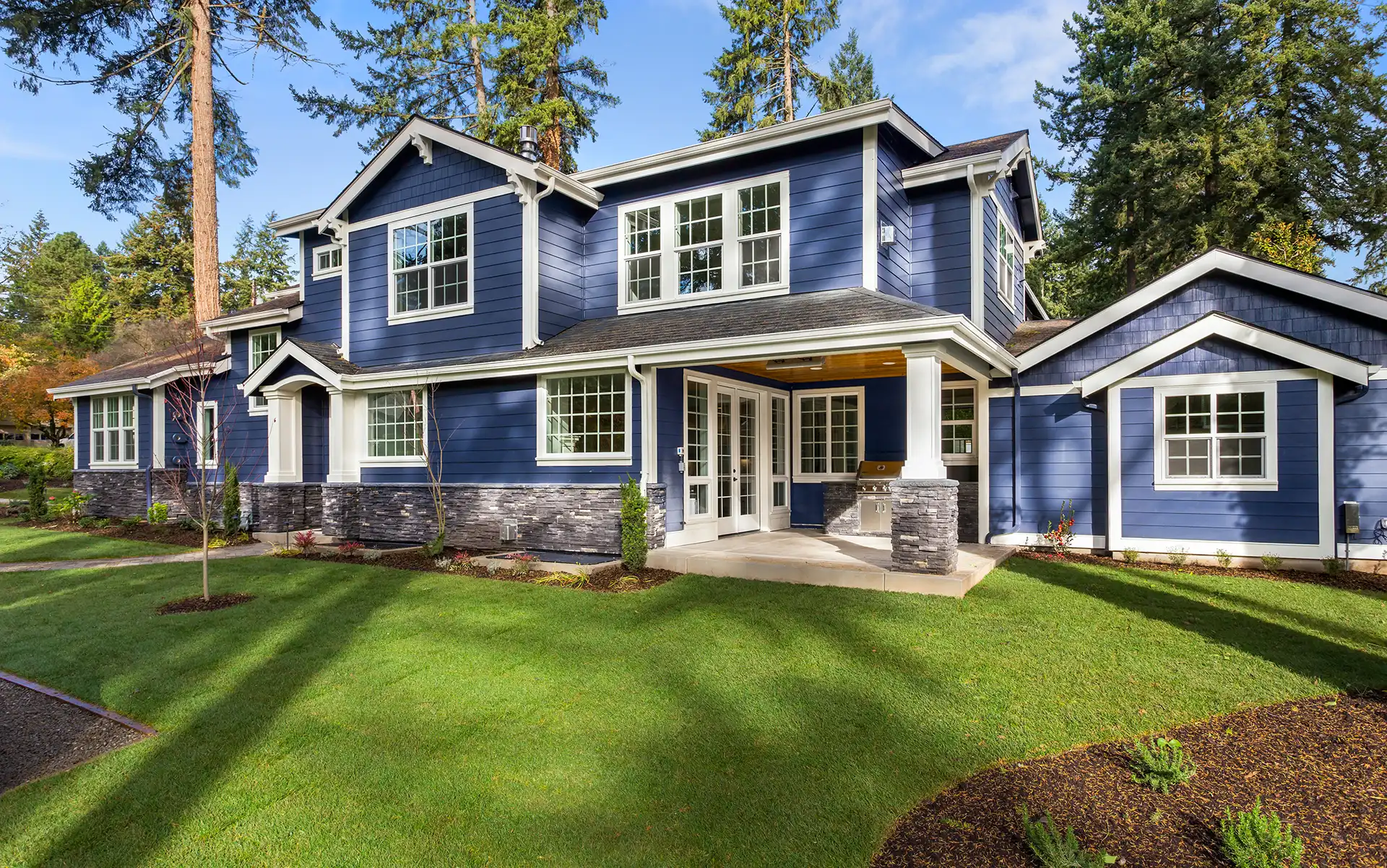 Blue two-story home with a glass-paneled front entry door