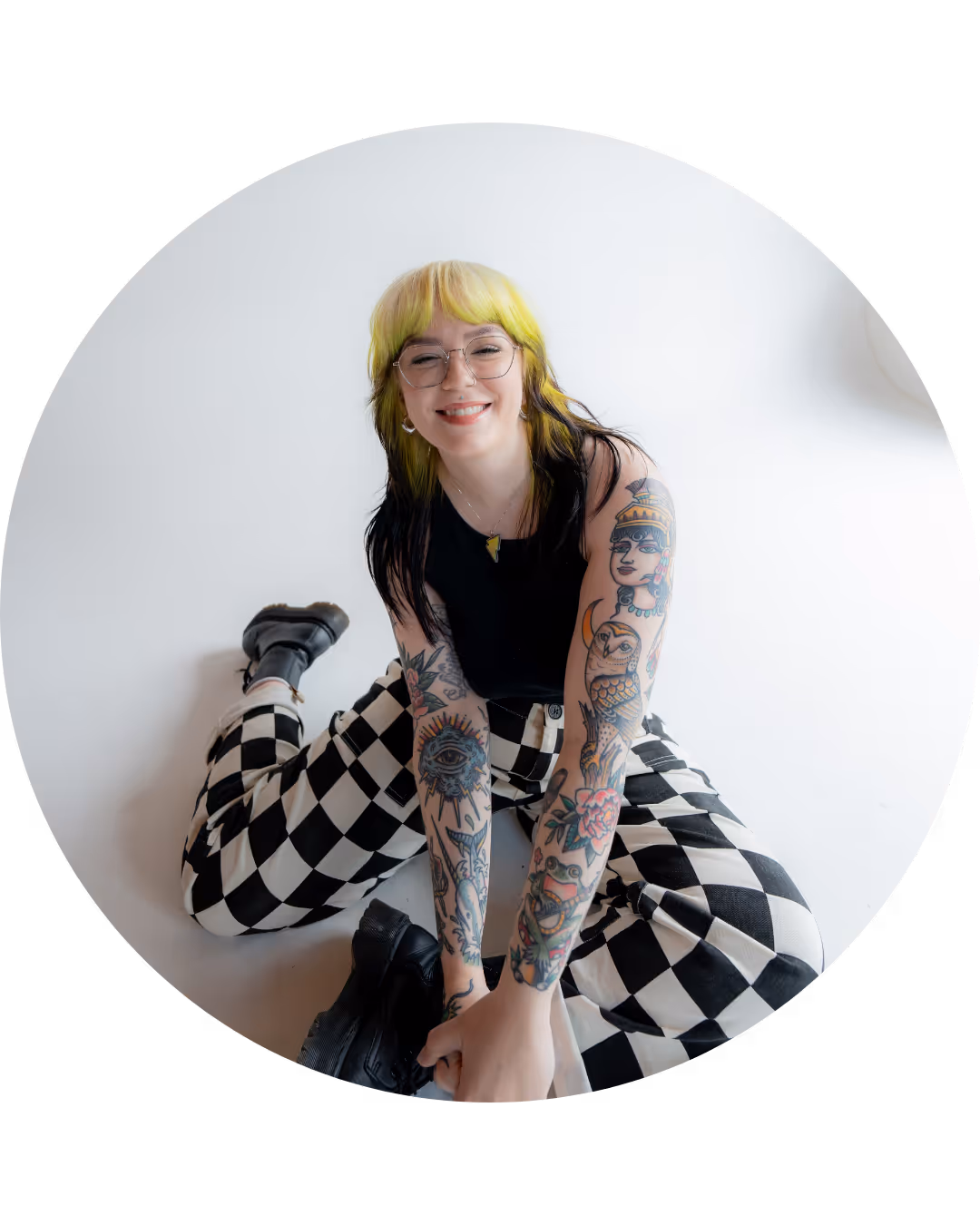 Marci, web designer, sits on the floor and is smiling at the camera.