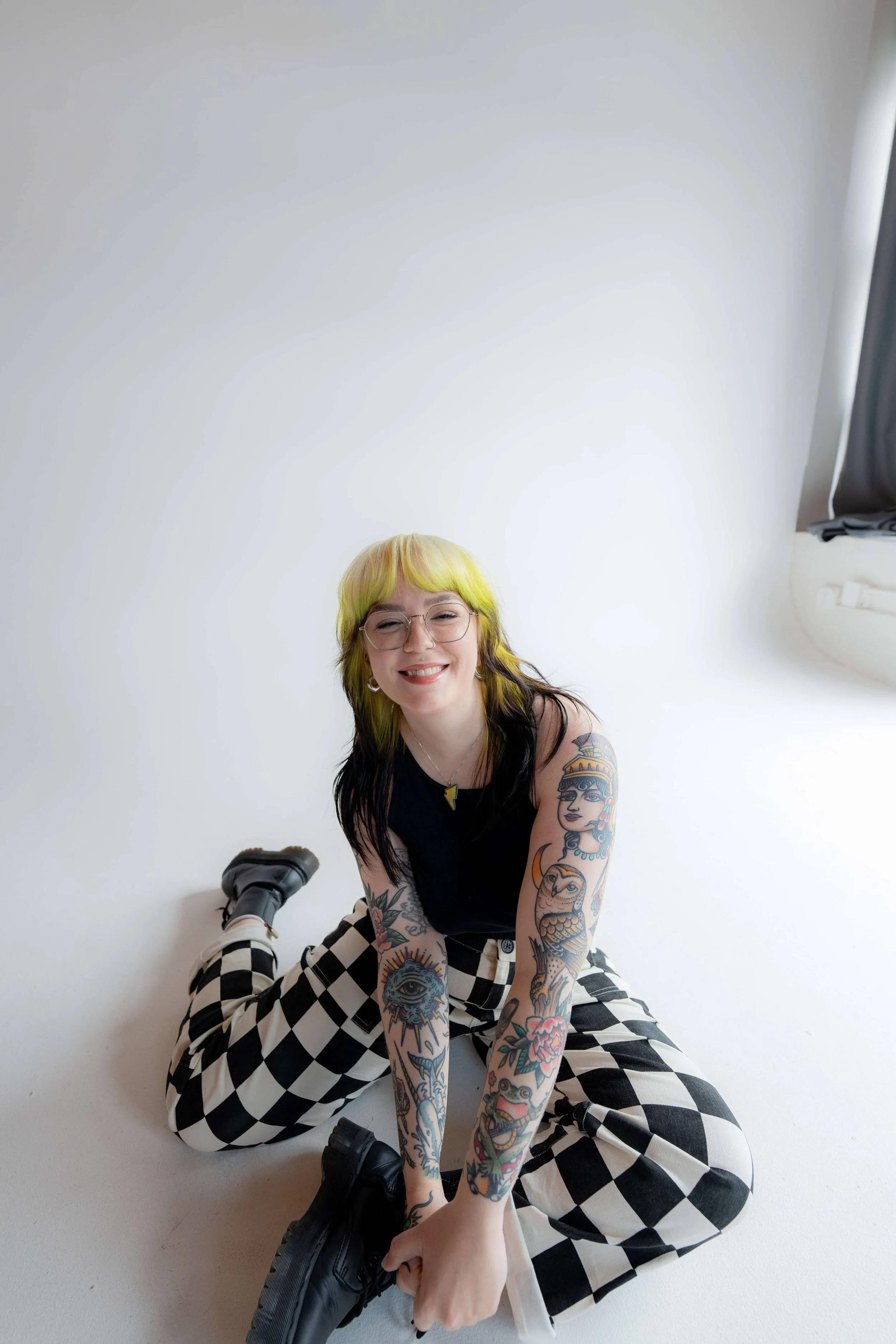 Marci, web designer and owner of Marmalade Creative Studio, sits on the floor smiling at the camera.