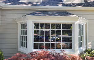 A bay window featuring elegant white trim, enhancing the room's natural light and providing a cozy view of the outdoors.