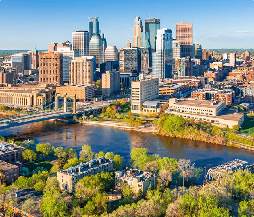 Minneapolis skyline featuring modern skyscrapers against a clear blue sky, showcasing the city's urban landscape.