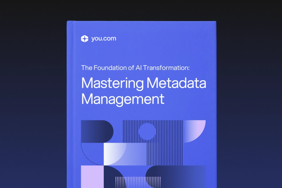 Blue book cover featuring the title “Mastering Metadata Management” with abstract geometric shapes and the you.com logo on a dark gradient background.