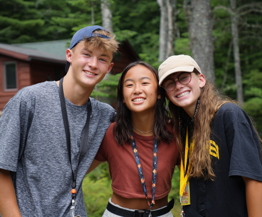 Drie tieners op kamp. Ze poseren voor de foto.
