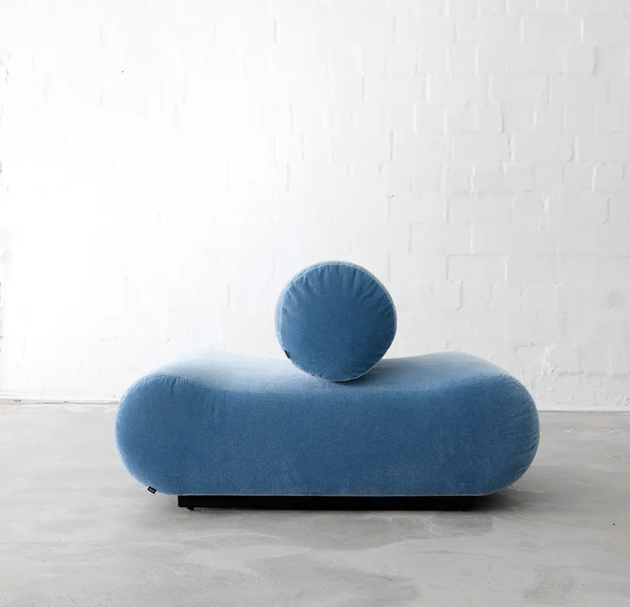 Minimalist blue upholstered bench with cylindrical backrest