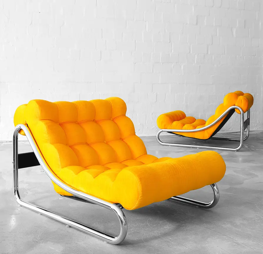 Pair of bold orange tufted lounge chairs with chrome frames