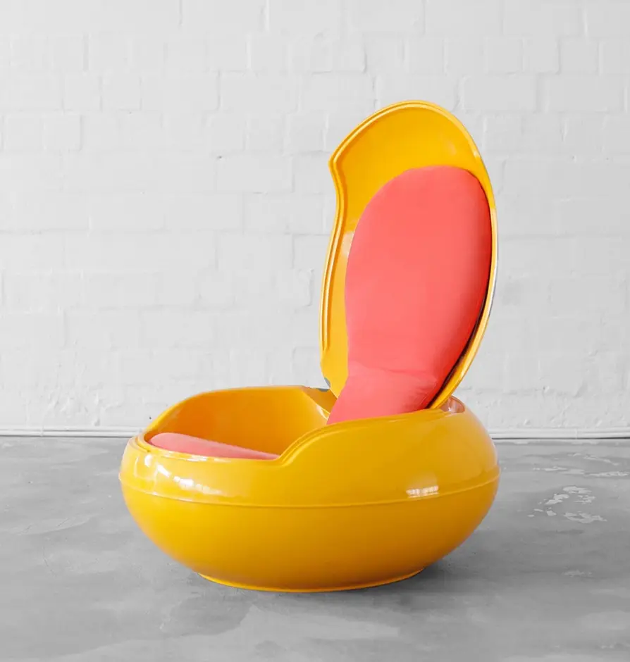 Retro yellow pod chair with pink cushions in open position.