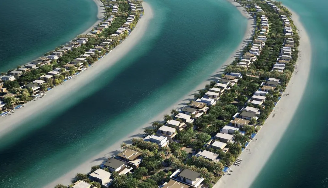 An aerial view of the Palm Jebel Ali villas surrounded by water, with a beach along its outer edge.