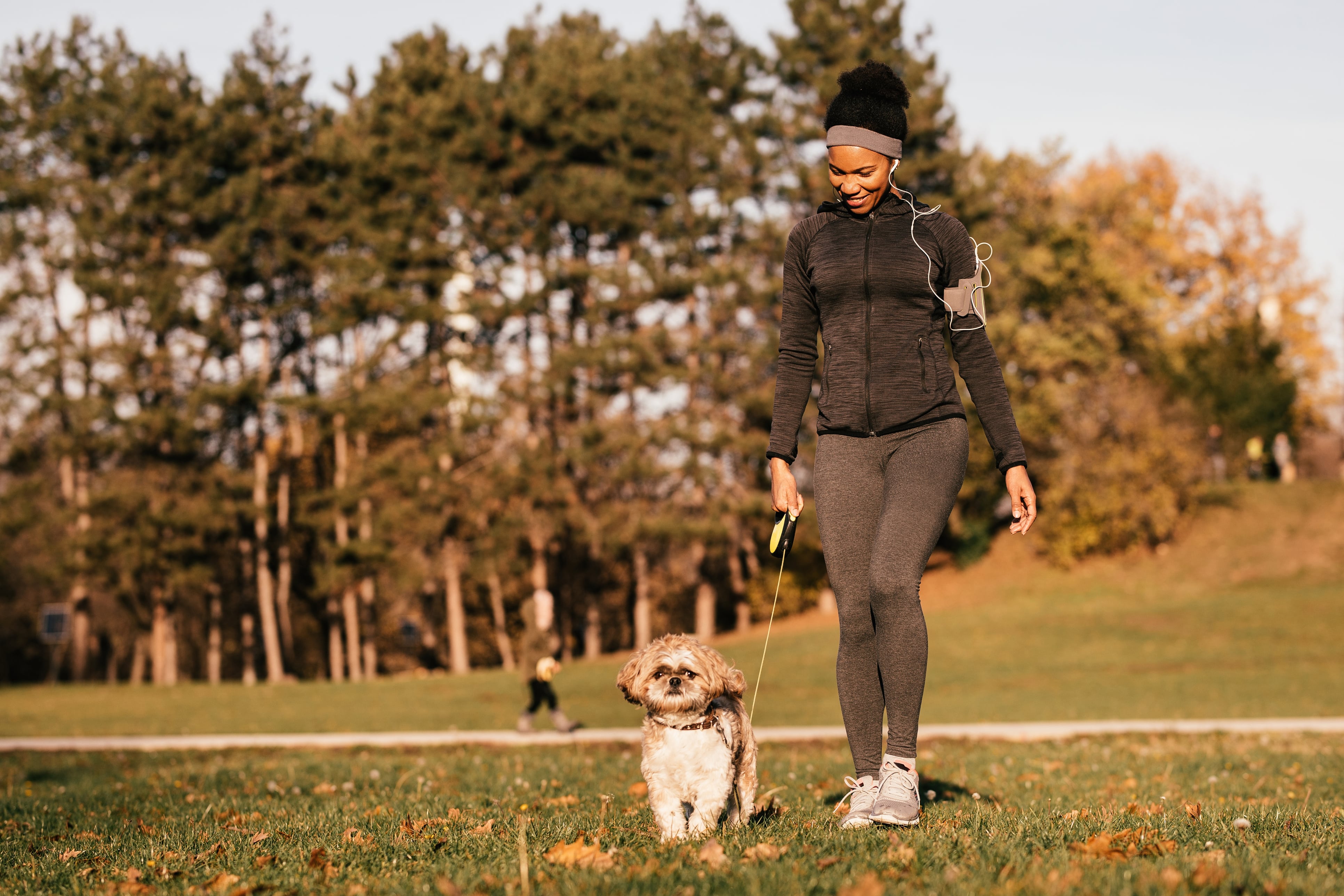 Woman in jogging gear walking a dog