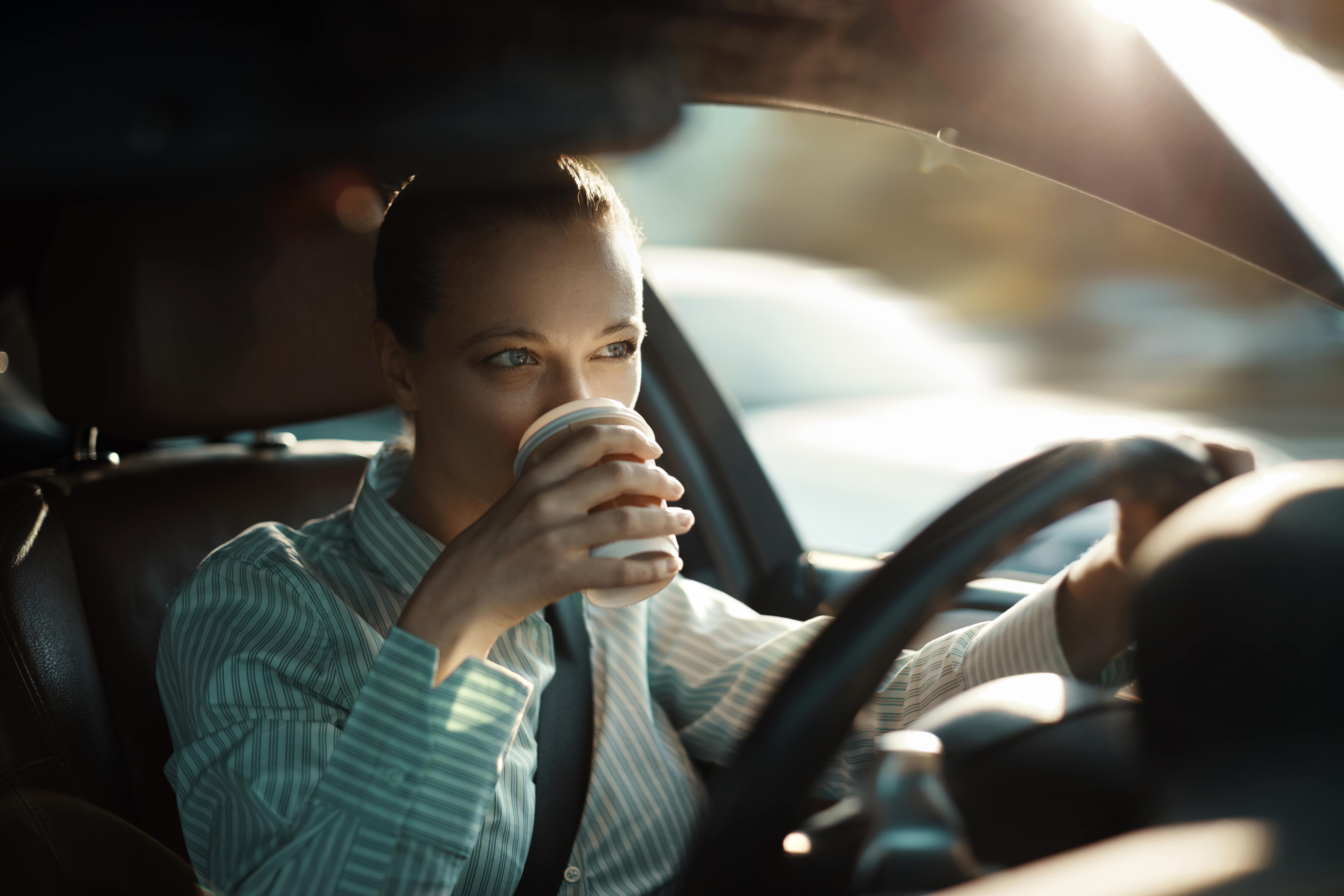 Woman sipping coffee in her vehicle