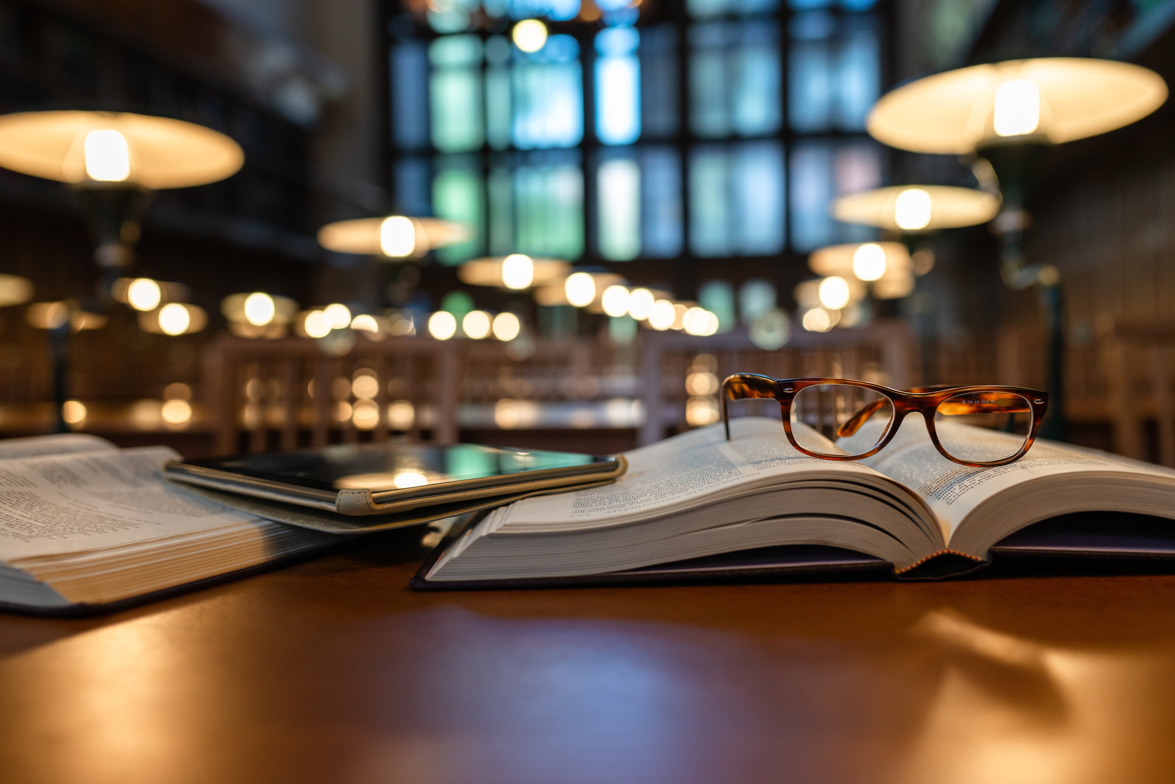 Pair of reading glasses left on an open book