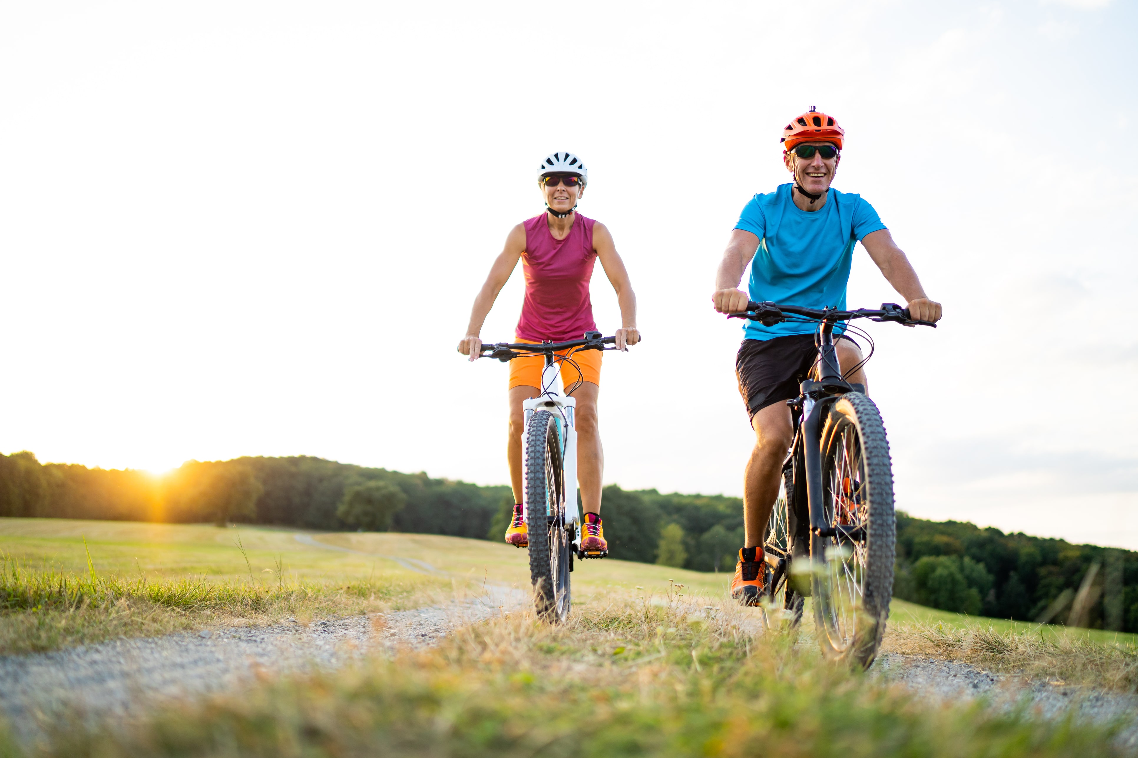 Senior couple cycling through a field
