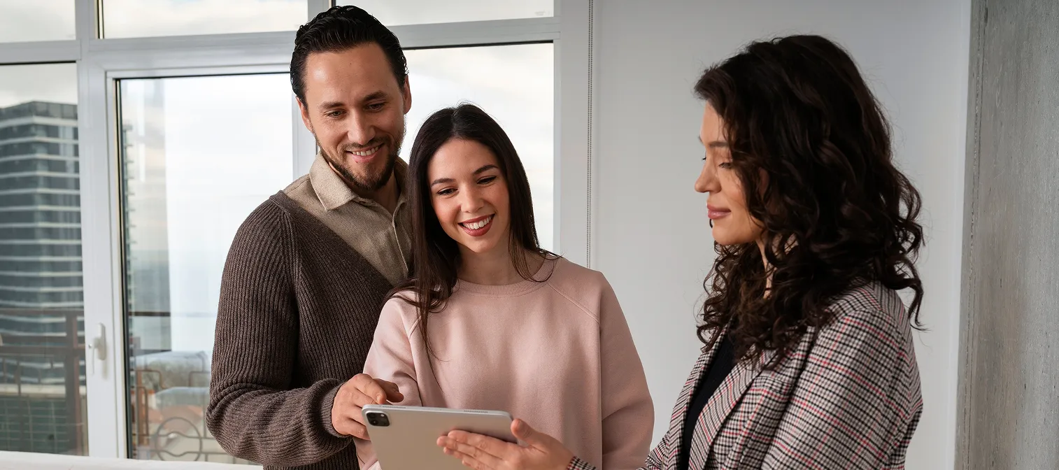 Agent reviewing a lease agreement with tenants on a tablet.