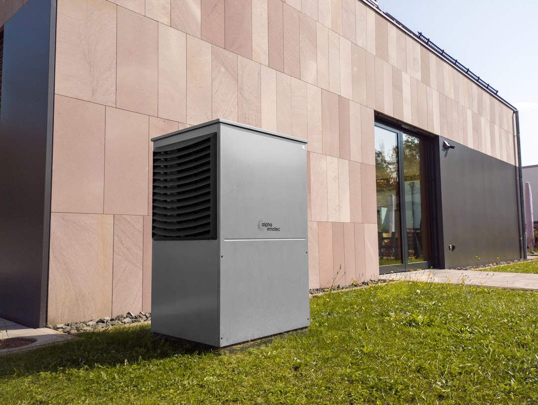 Outdoor HVAC condenser unit sitting on a concrete pad next to a residential home - central air vs mini split for pittsburgh