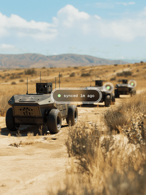 UGVs driving through a desert trail show their on-board edge AI systems were synced one minute ago