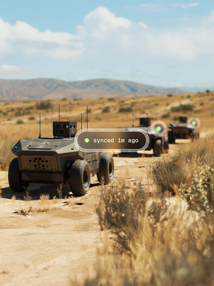 UGVs driving through a desert trail show their on-board edge AI systems were synced one minute ago