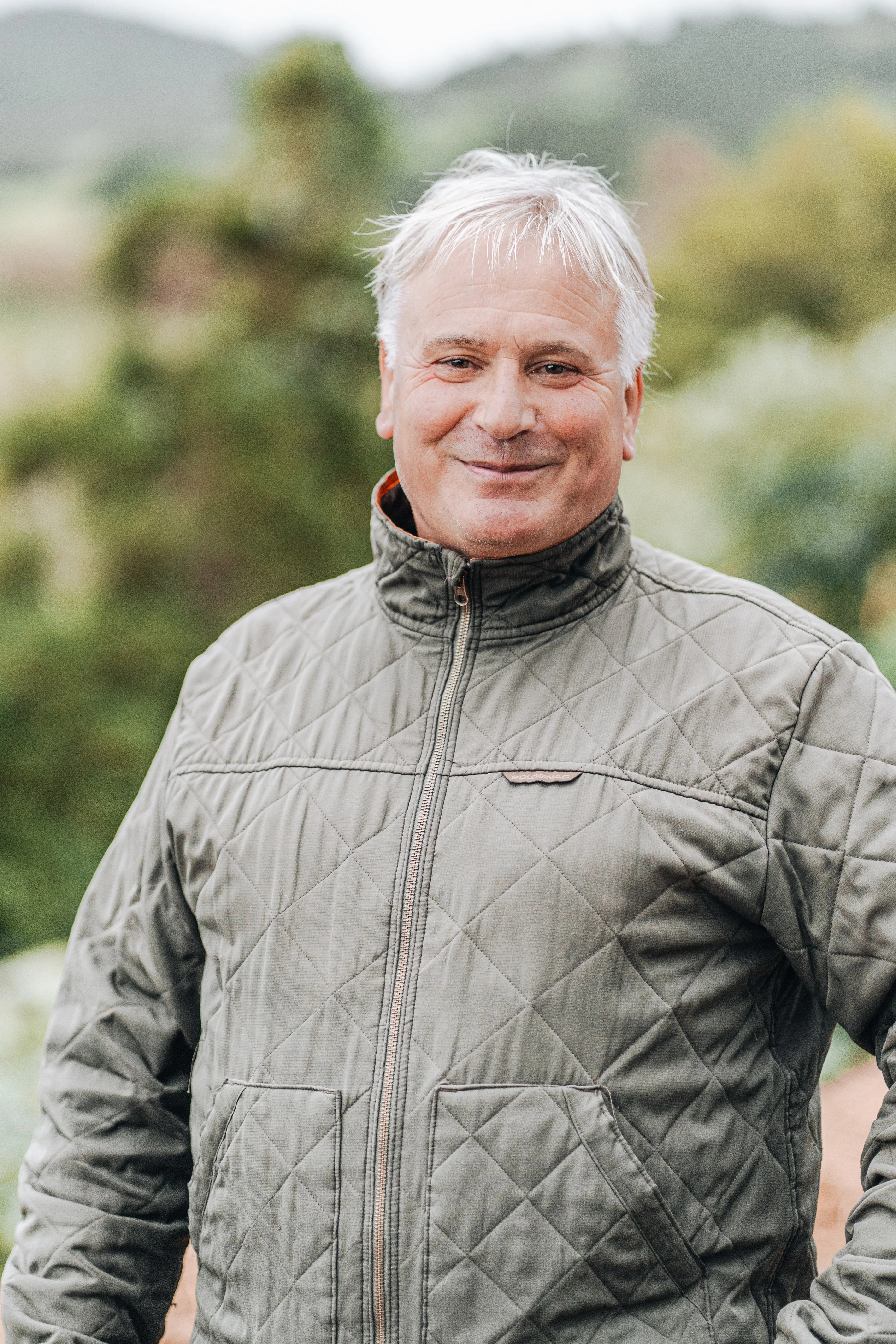 a man with white hair and a quilted jacket