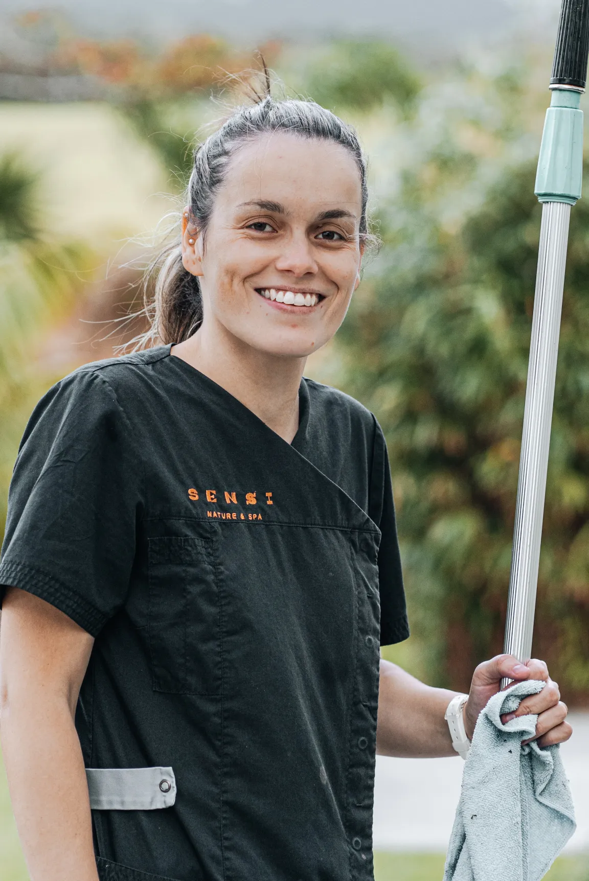 a smiling woman holding an umbrella in her hand