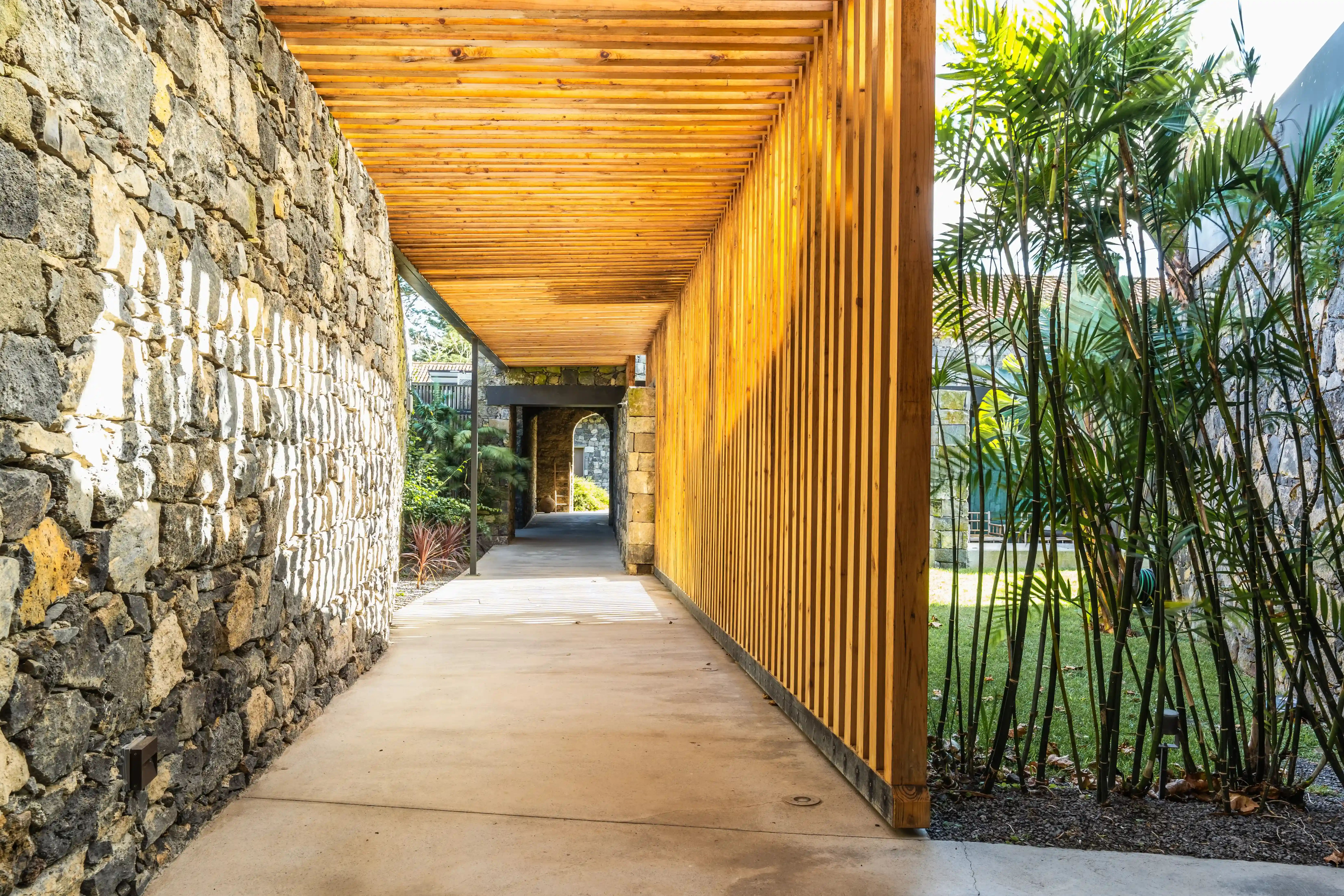 a walkway between two buildings with a wooden roof