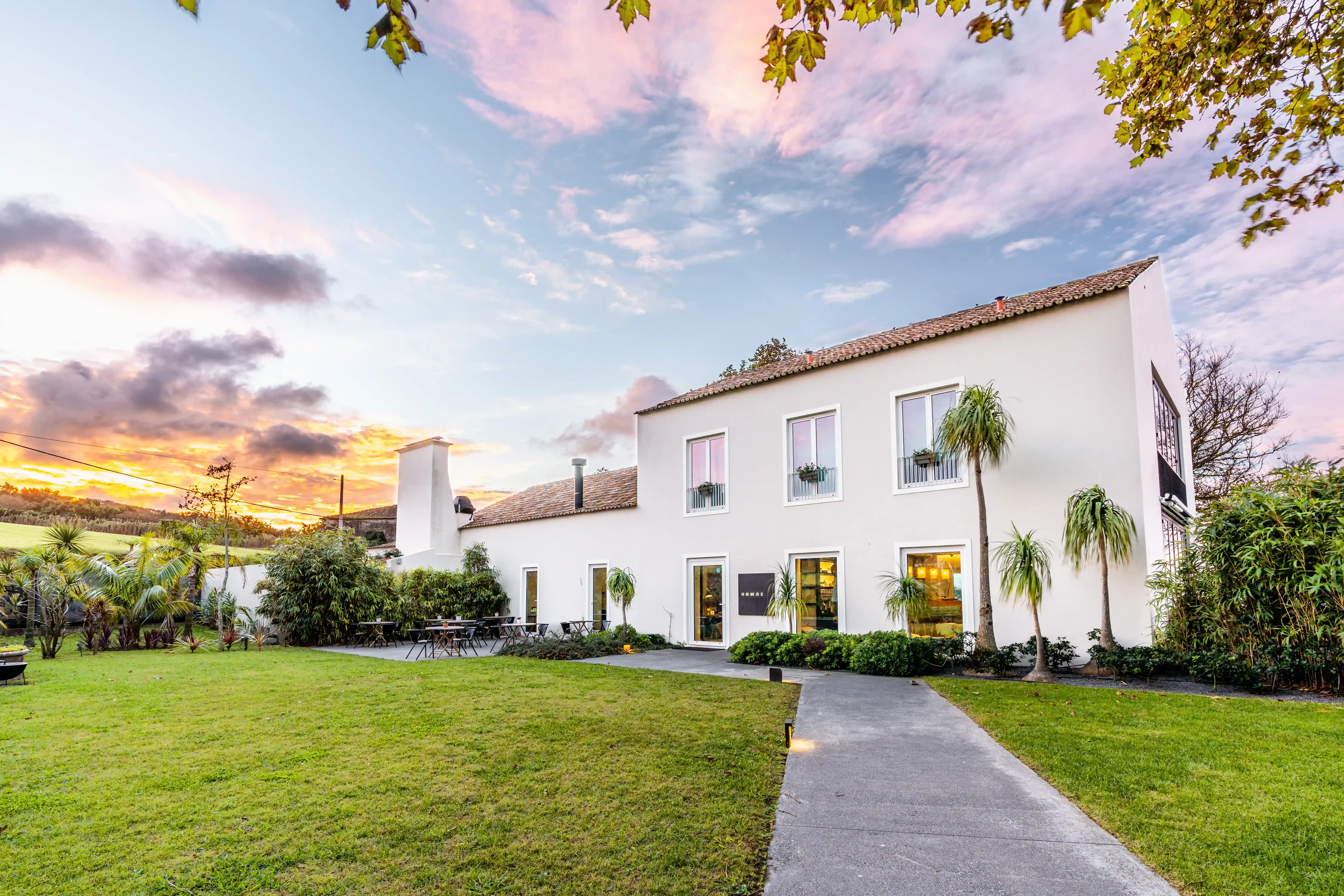 a large white house sitting on top of a lush green field