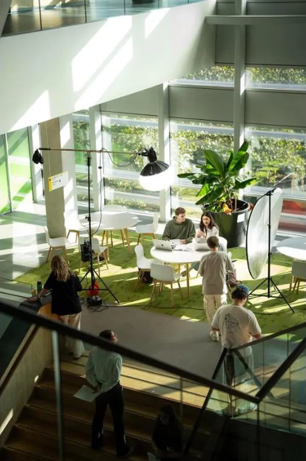 Filmset met lampen en reflectiescherm in de lichte hal van Universiteit Utrecht