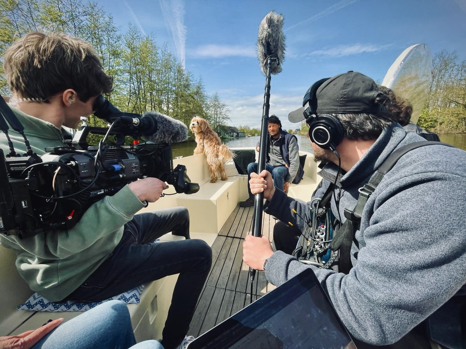 Filmcrew filmt hond Zwabber en een acteur tijdens een scène op een boot.