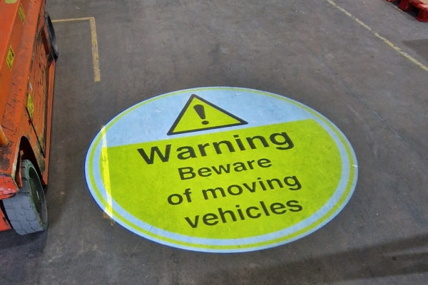 Projected warning sign: 'Beware Moving Vehicles' in UK brewery logistics zone