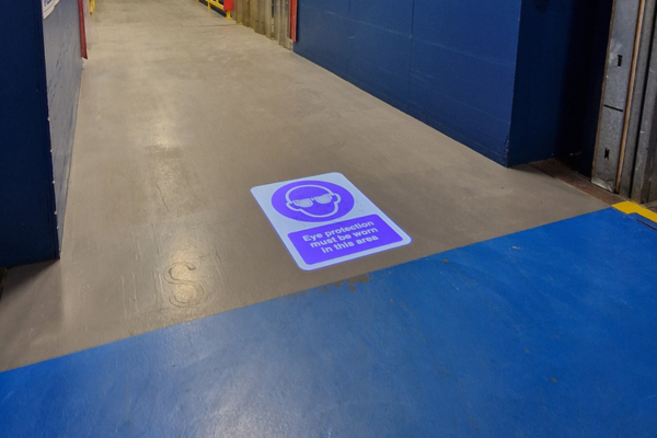 LED safety sign projected on floor in aircraft production area
