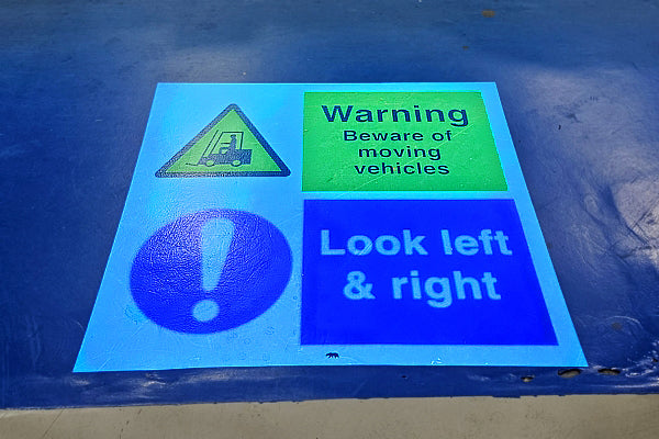 LED safety sign projected on floor in aircraft production area