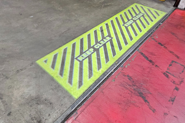 Projected 'Keep Clear' safety sign near aerospace engine testing bay