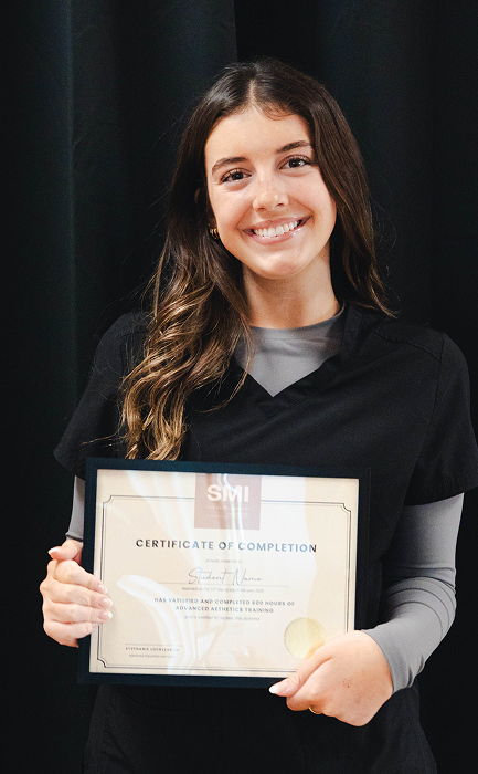 SMI student celebrating graduation from aesthetics and makeup program