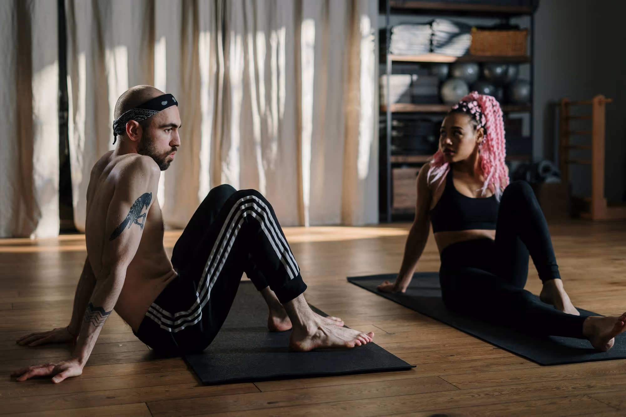 Two people stretching on yoga mats