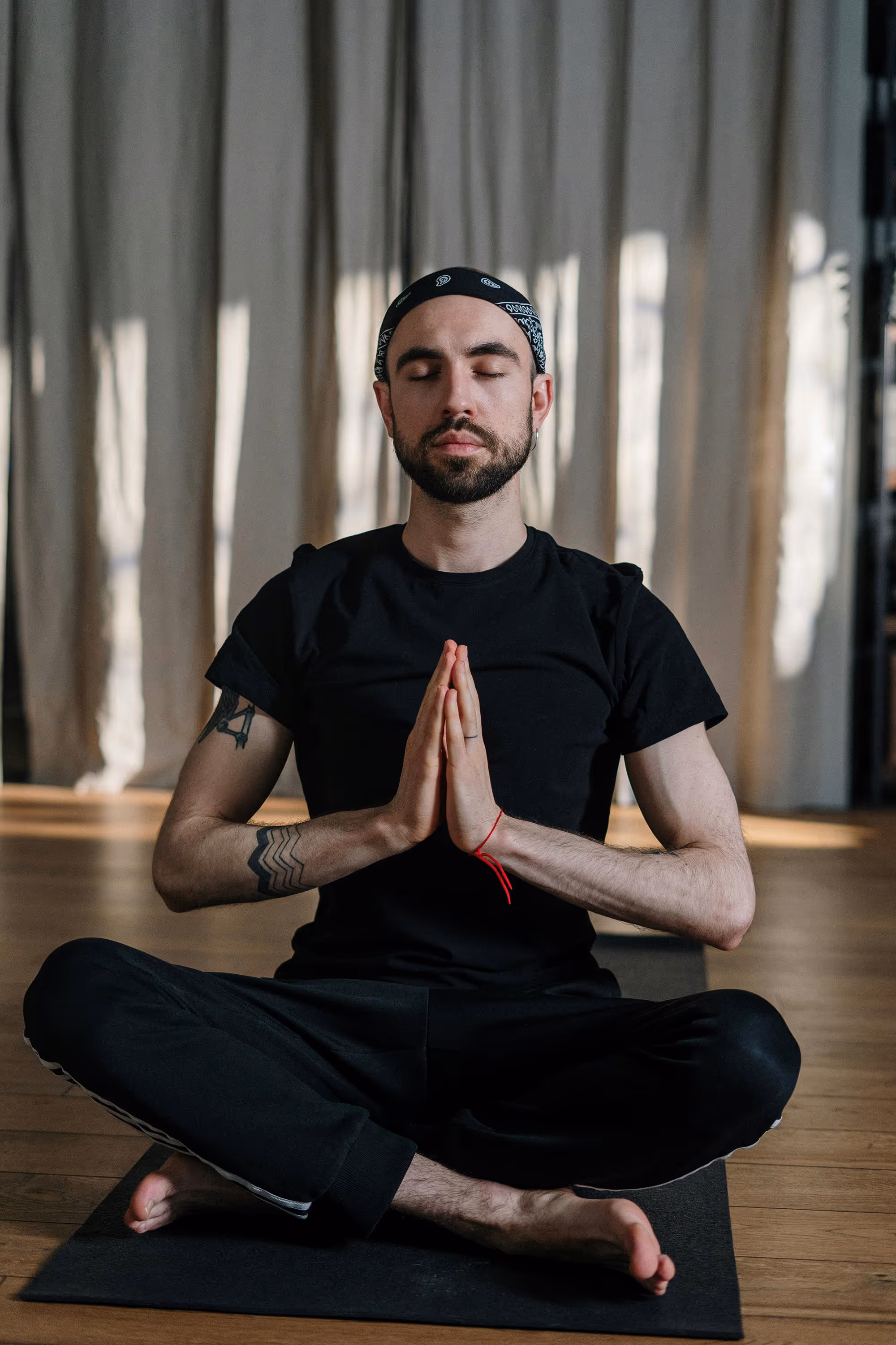 Man meditating in seated yoga pose with eyes closed