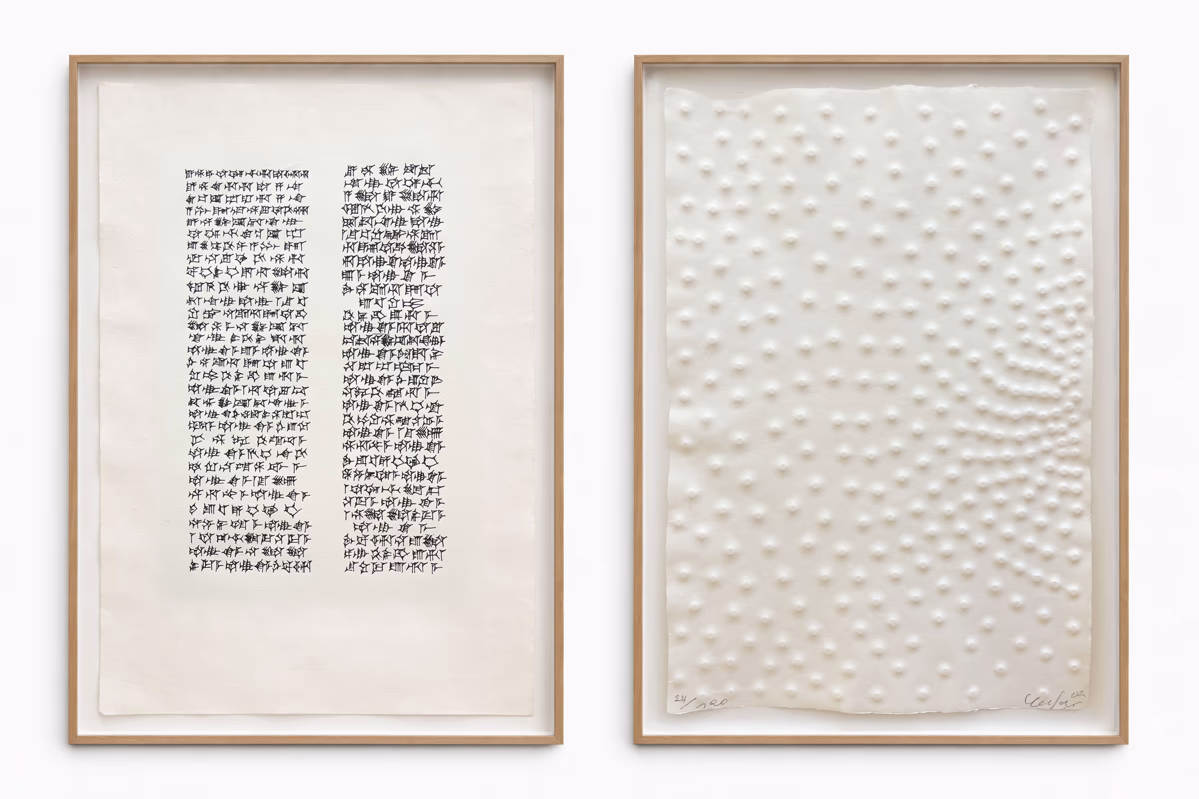 Zwei gerahmte Kunstwerke nebeneinander: links zwei vertikale Spalten mit keilschriftähnlichen schwarzen Symbolen auf weißem Papier, rechts weiße geprägte Punkte auf weißem Papier mit organischer Anordnung.