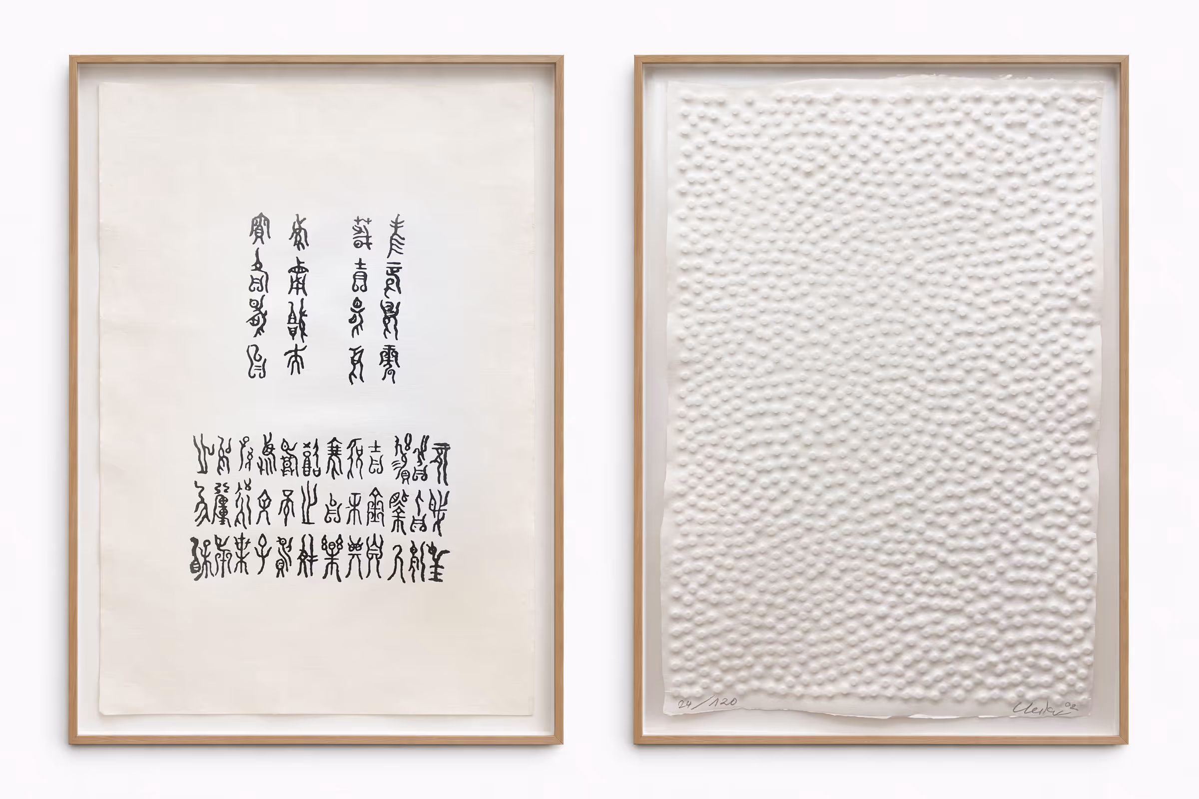 Zwei eingerahmte Kunstwerke, links mit schwarzer ostasiatischer Kalligraphie auf hellem Papier, rechts eine strukturierte weiße Relieffläche mit erhabenen Punkten.