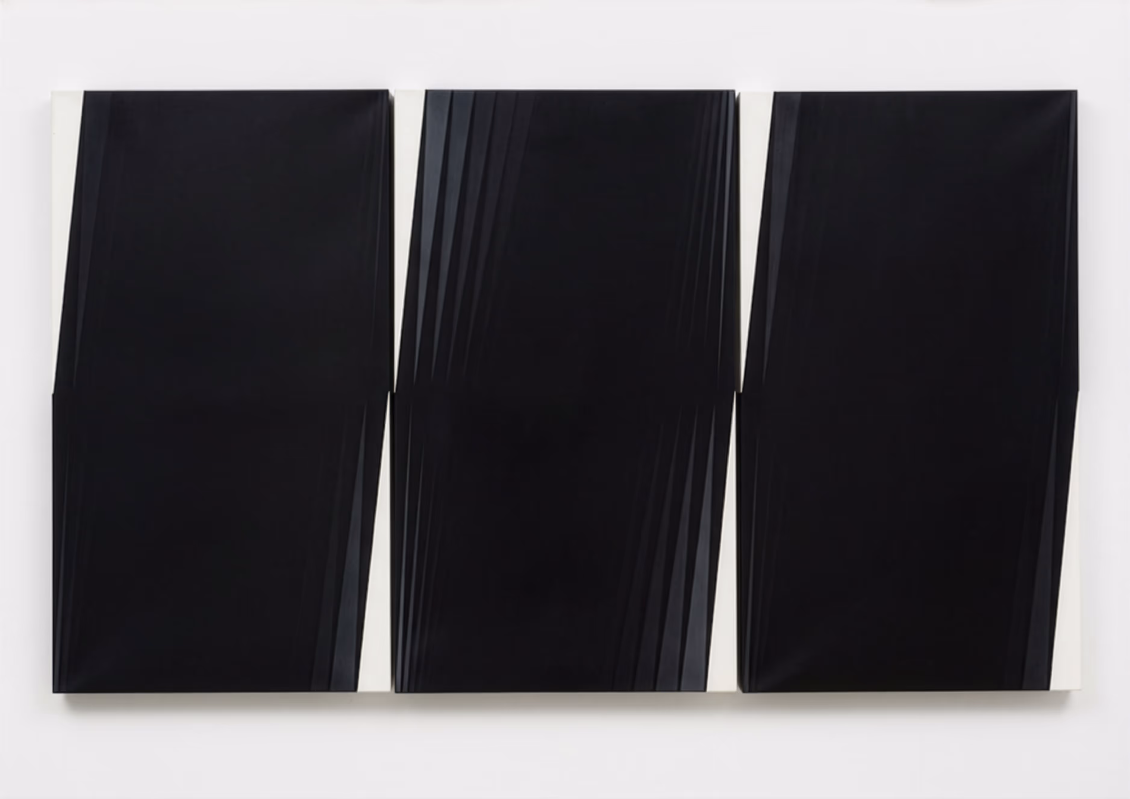 Zwei gerahmte Kunstwerke: links ein Blatt mit schwarzer Kalligrafie auf weißem Papier, rechts eine strukturierte weiße Oberfläche mit erhabenen Punkten.