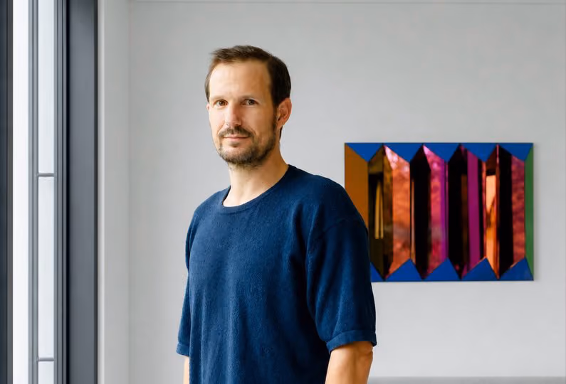 Galerieraum mit drei abstrakten Gemälden von Martina Ziegler in dunklen Rahmen, die organisch geformte, verschlungene Muster in verschiedenen Erdtönen und Rottönen zeigen.