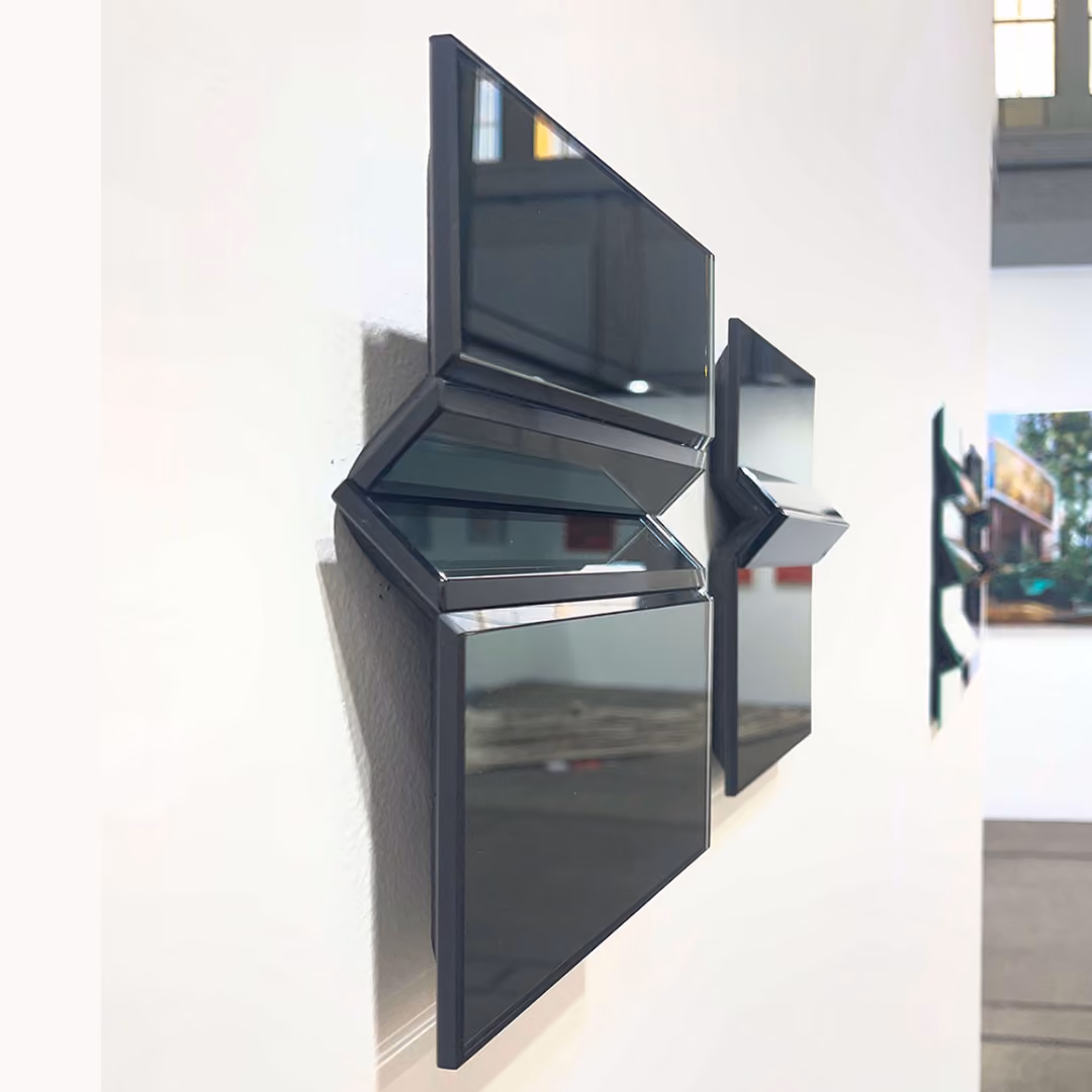 Zwei Frauen betrachten moderne, farbige, geometrische Kunstwerke in einer Galerie mit weißen Wänden.