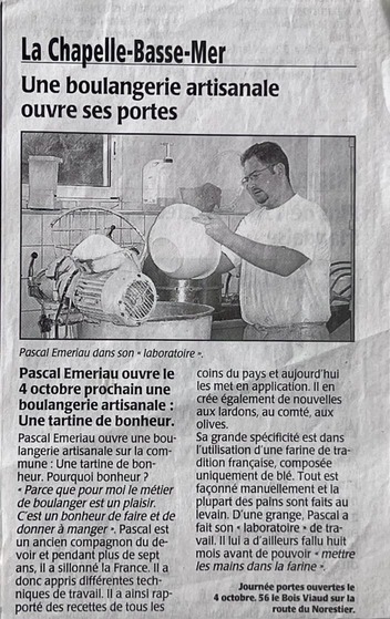 Pascal Emeriau dans son laboratoire verse de la pâte à pain dans un bol, préparant l'ouverture de sa boulangerie artisanale à La Chapelle-Basse-Mer.