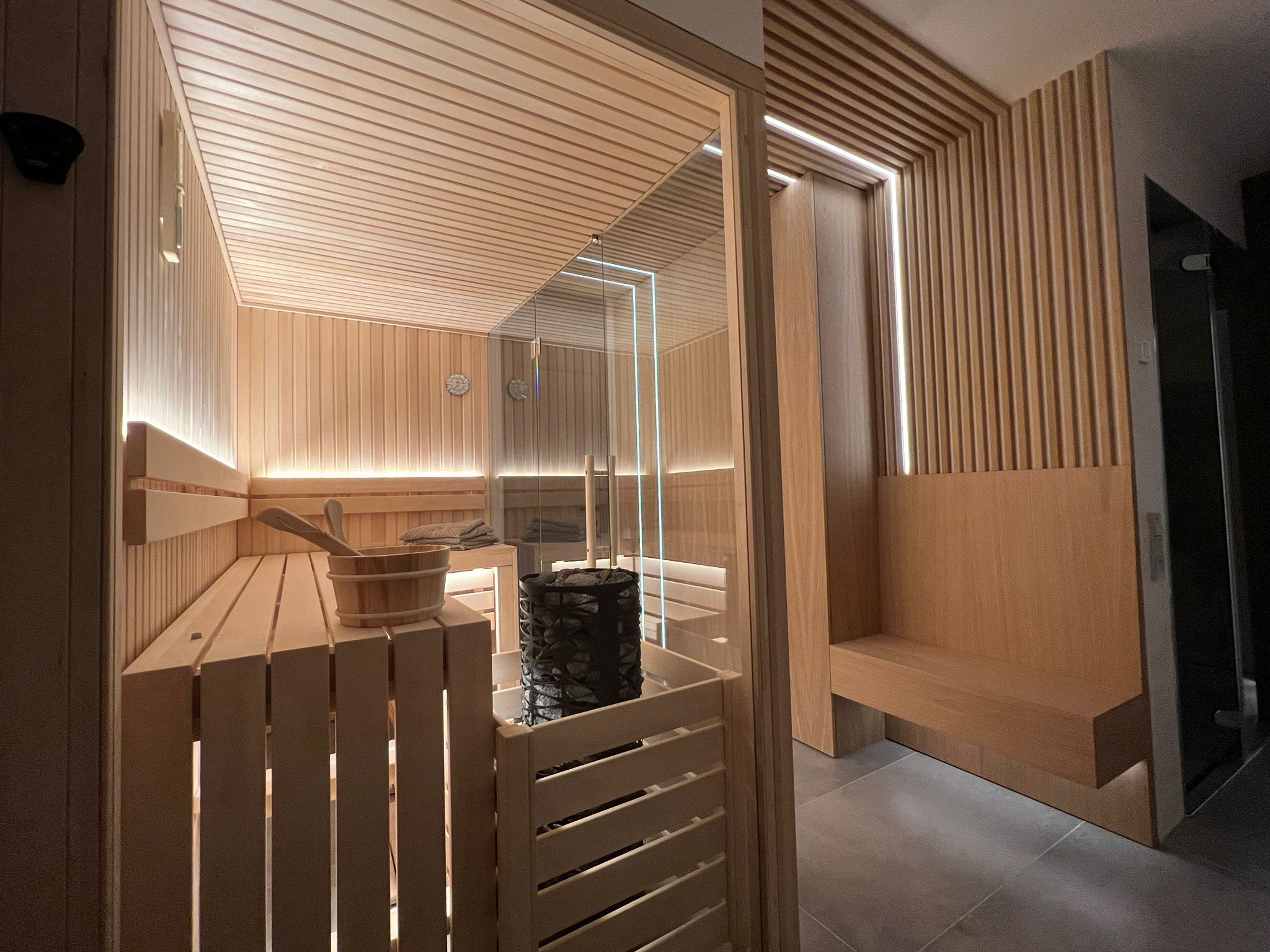 Modern indoor sauna with glass walls and sleek led lighting