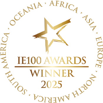 Gold award emblem with star and ribbon design reading 'IE100 WINNER'.