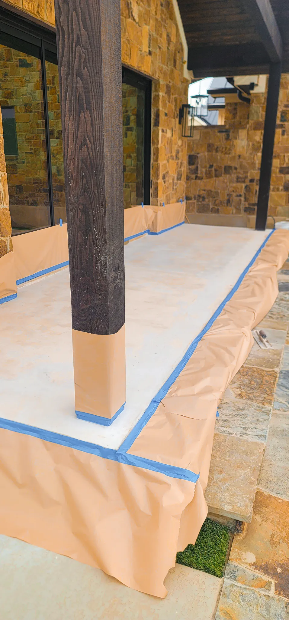 Concrete patio floor outside a modern stone wall home