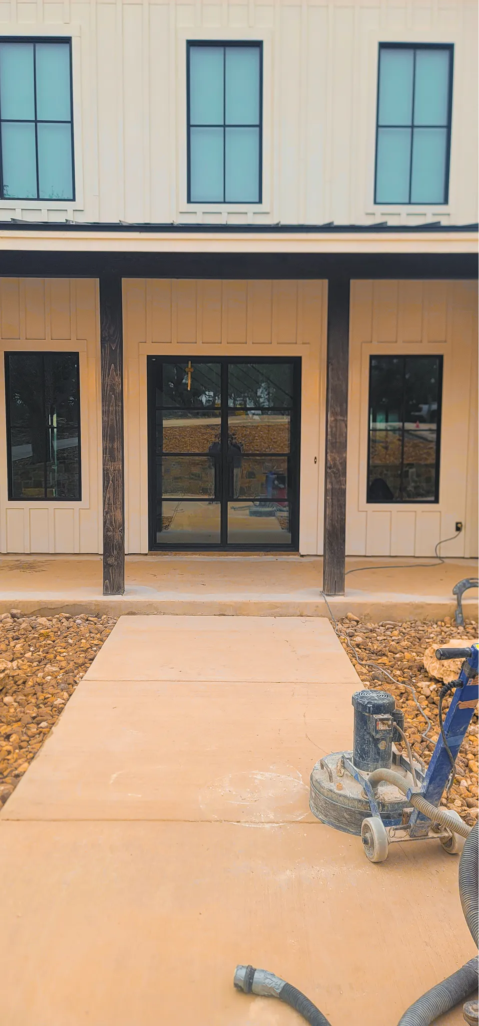 Concrete patio floor outside a modern wood-paneled home