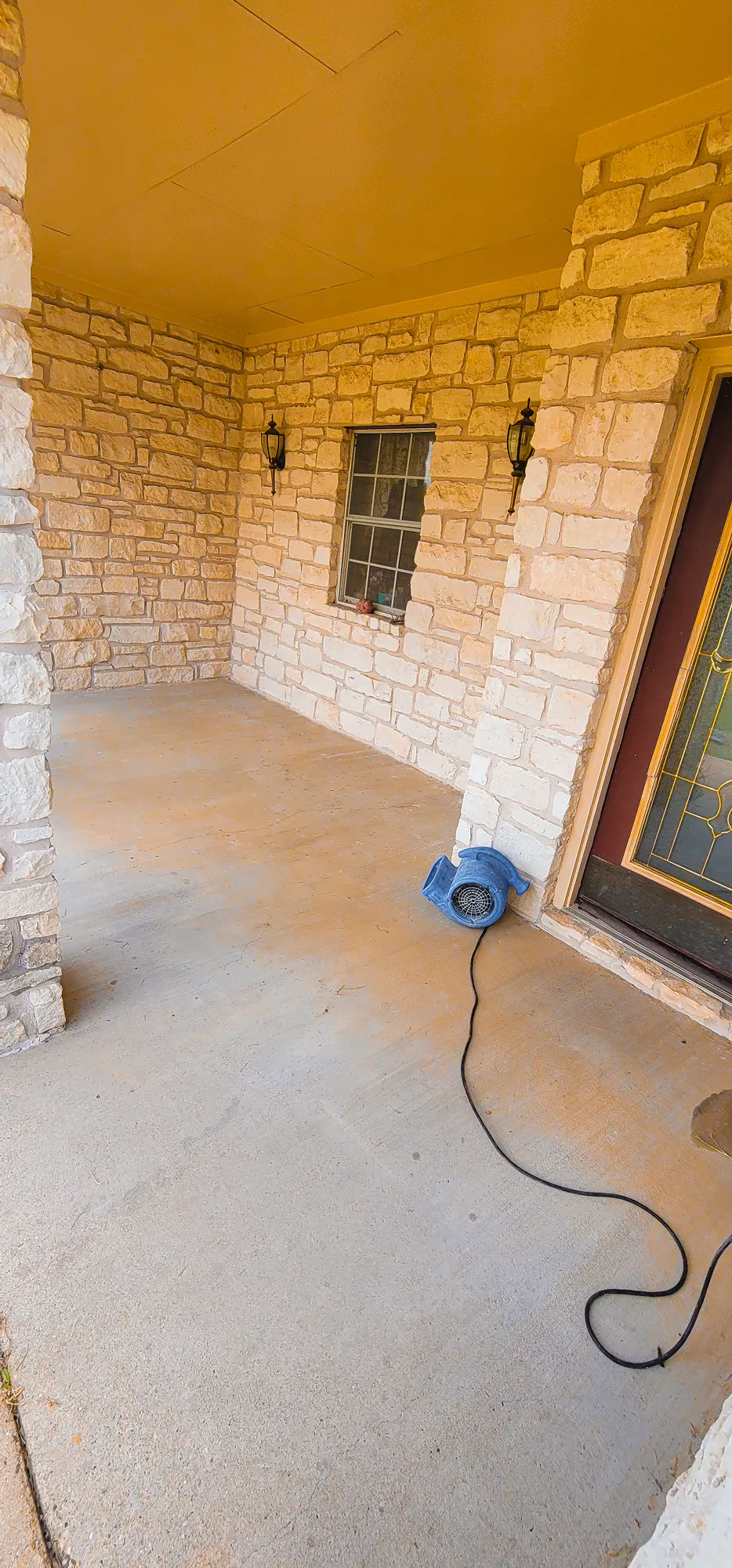 Concrete patio floor outside a modern stone brick home
